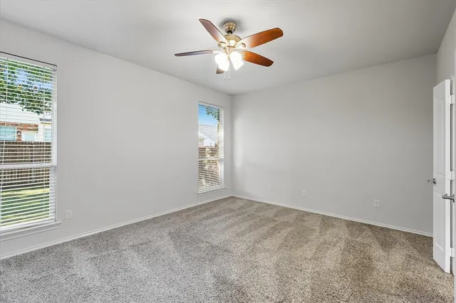 an empty room with window and a ceiling fan