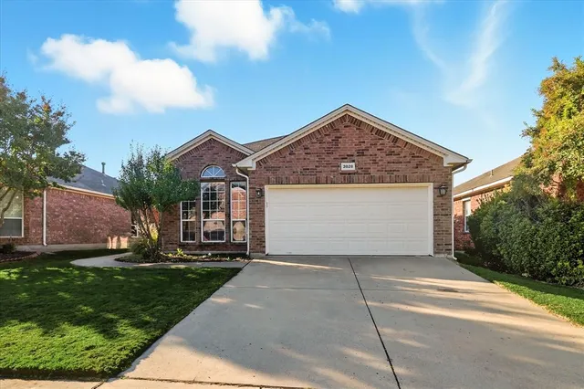a front view of a house with a garden and trees