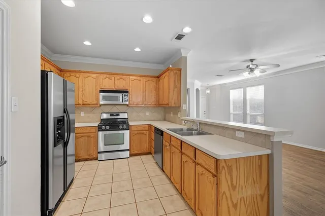 a large kitchen with stainless steel appliances granite countertop a sink and cabinets