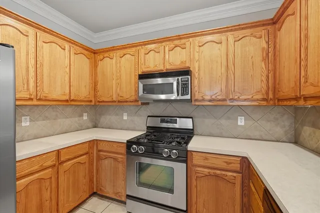 a kitchen with stainless steel appliances granite countertop a stove a sink and a microwave