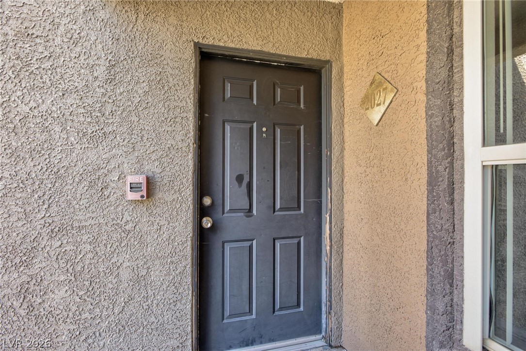 6650 West Warm Springs Road, Unit 2027 Las Vegas, NV 89118 - Photo 5 of 29 The entry features a textured facade with a dark paneled door.