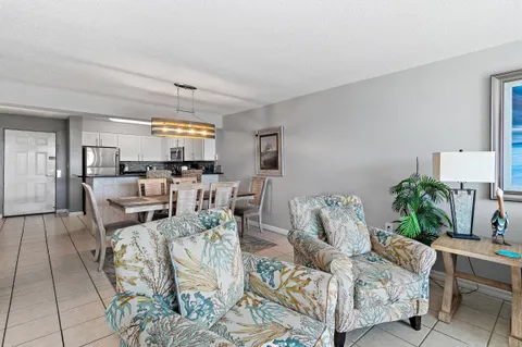 a dining room with stainless steel appliances kitchen island granite countertop a dining table chairs and a refrigerator