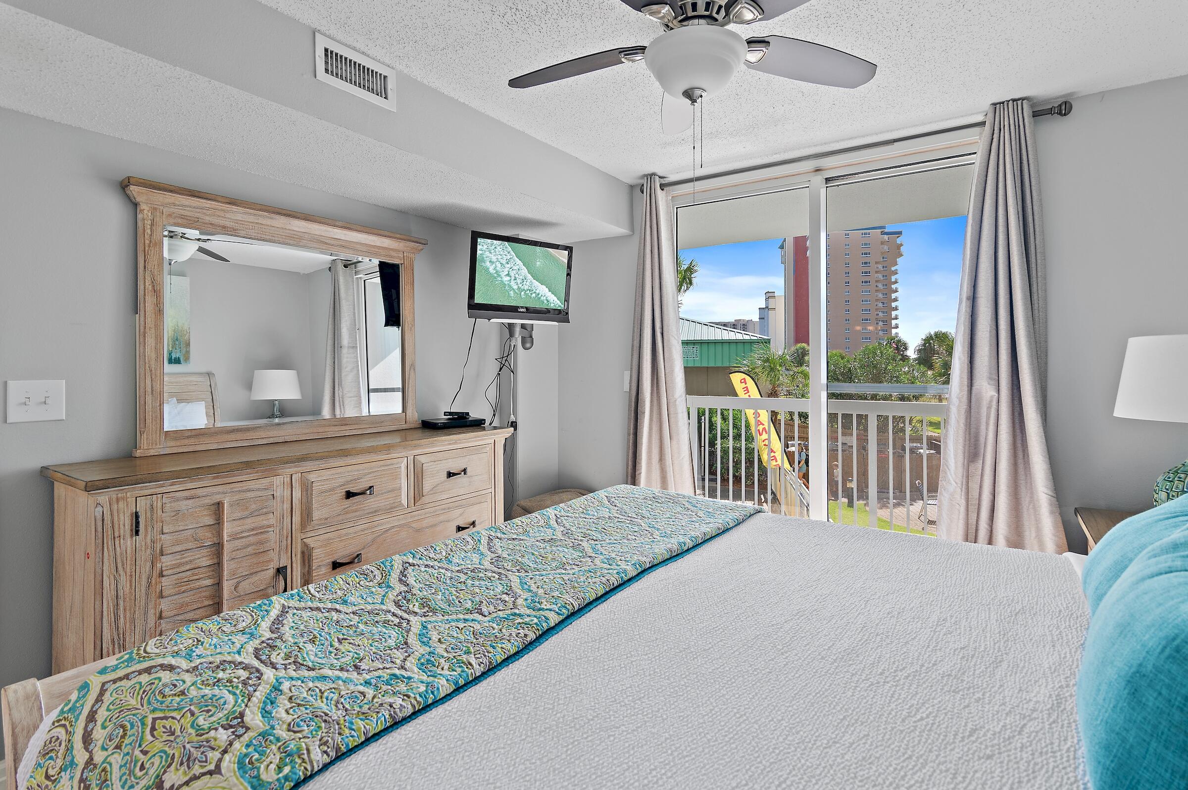 1002 Highway 98, Unit 217 Destin, FL 32541 - Photo 27 of 48 a bedroom with a large bed and a flat tv screen on dresser