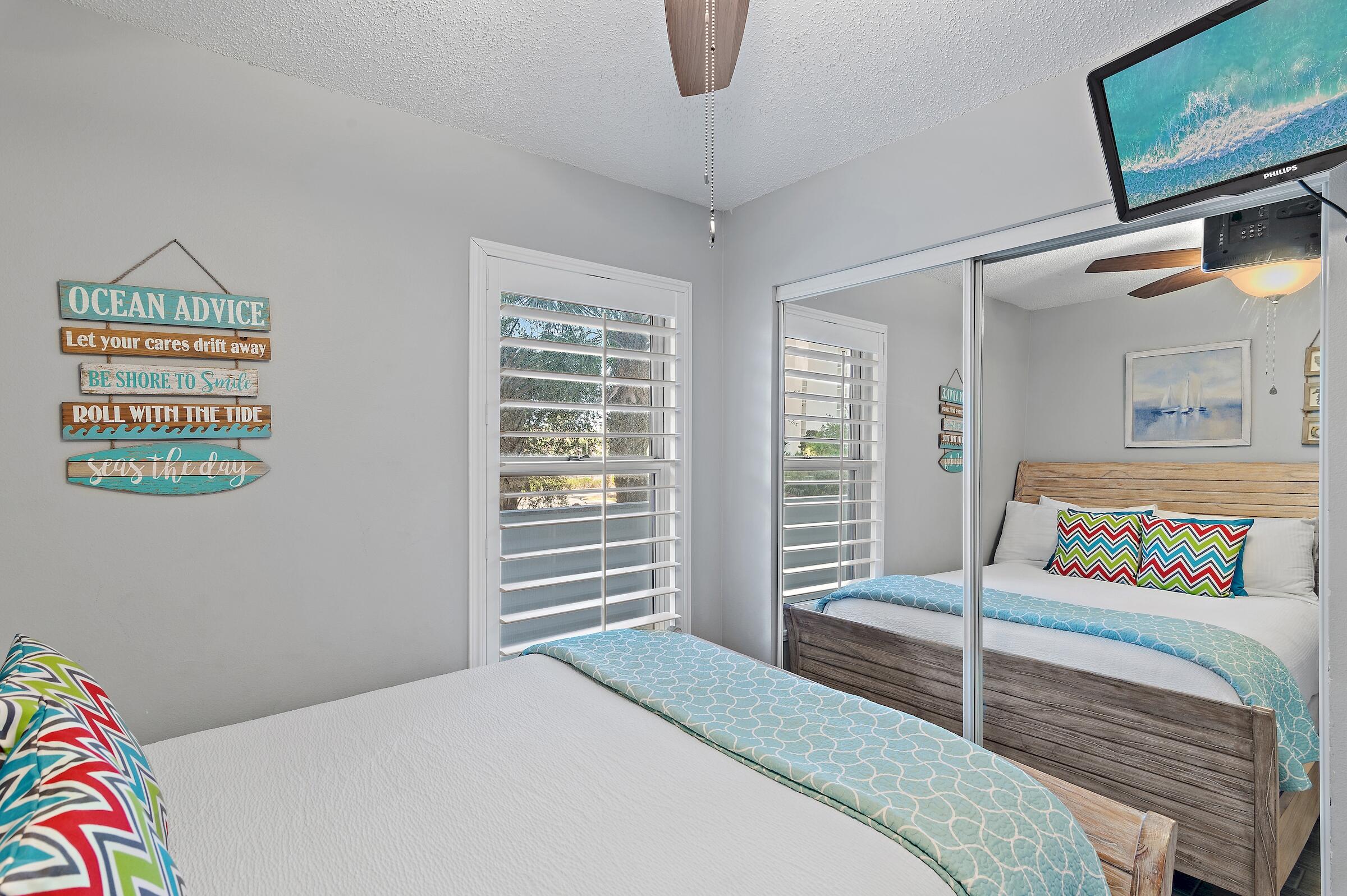 1002 Highway 98, Unit 217 Destin, FL 32541 - Photo 35 of 48 a bedroom with a bed a mirror and a window