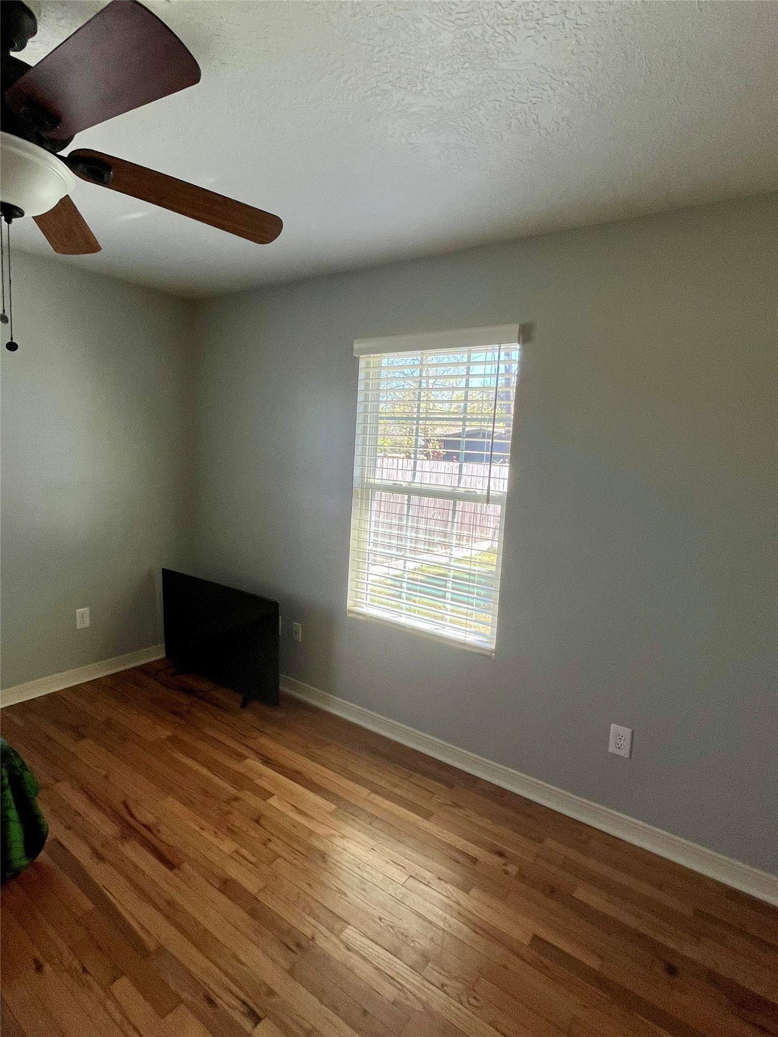 208 Oddo Street Houston, TX 77022 - Photo 5 of 10 an empty room with wooden floor and windows