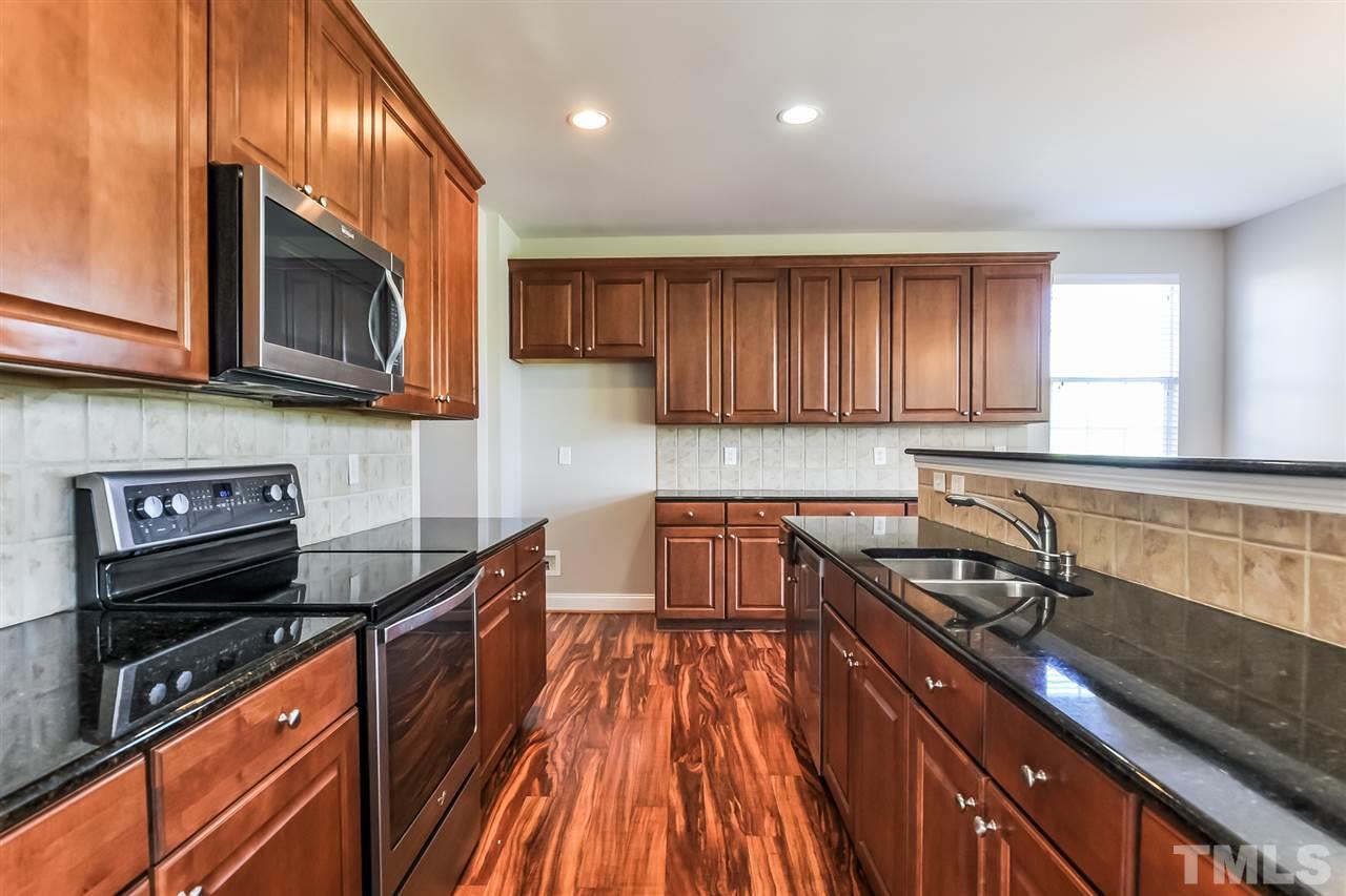 187 Solheim Lane Raleigh, NC 27603 - Photo 2 of 25 a kitchen with granite countertop wooden cabinets stainless steel appliances and a sink