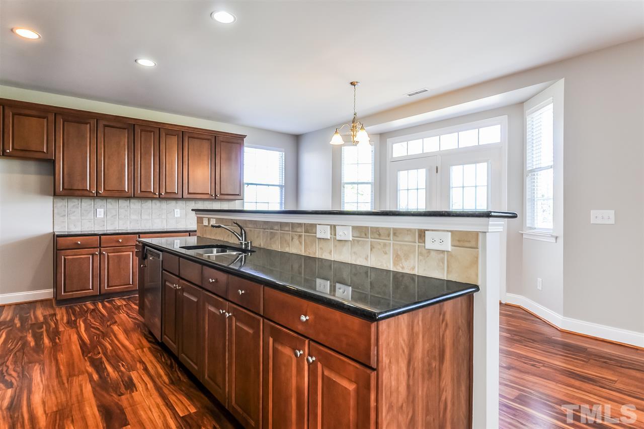 187 Solheim Lane Raleigh, NC 27603 - Photo 14 of 25 a kitchen with granite countertop a sink stove and cabinets