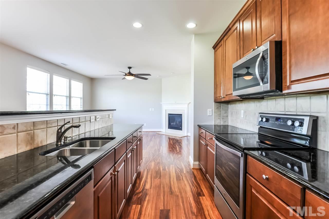187 Solheim Lane Raleigh, NC 27603 - Photo 15 of 25 a kitchen with granite countertop a stove and a sink