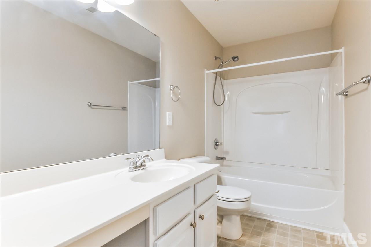 187 Solheim Lane Raleigh, NC 27603 - Photo 23 of 25 a bathroom with a granite countertop sink a toilet and shower
