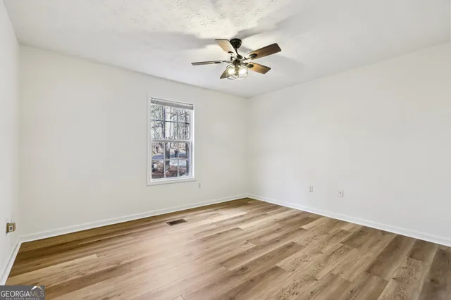 a view of a room with wooden floor and fan