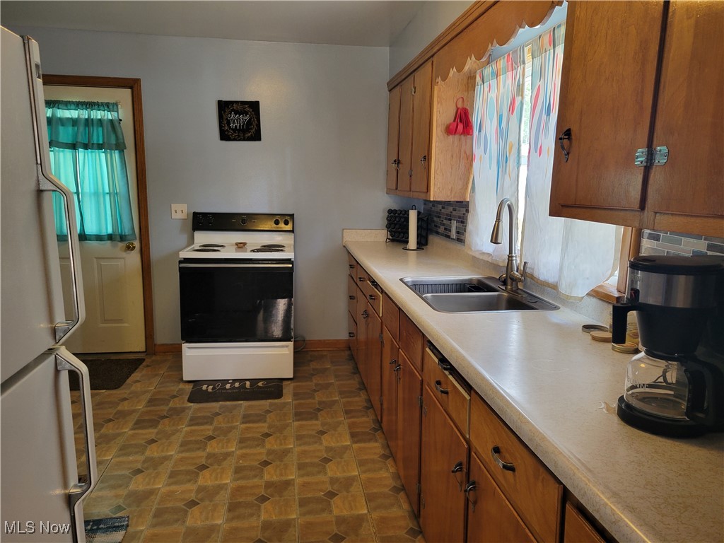 101 Eastport Road Scio, OH 43988 - Photo 8 of 30 Kitchen featuring plenty of natural light, white appliances, decorative backsplash, and sink