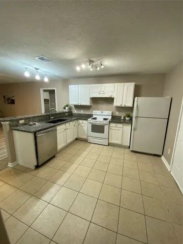 a kitchen with stainless steel appliances a sink a stove a microwave and cabinets