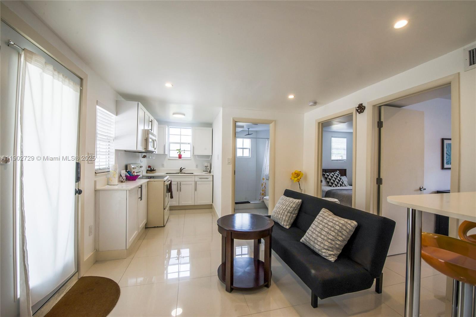 a open kitchen with white cabinets and stainless steel appliances