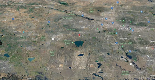 an aerial view of residential houses with outdoor space and trees