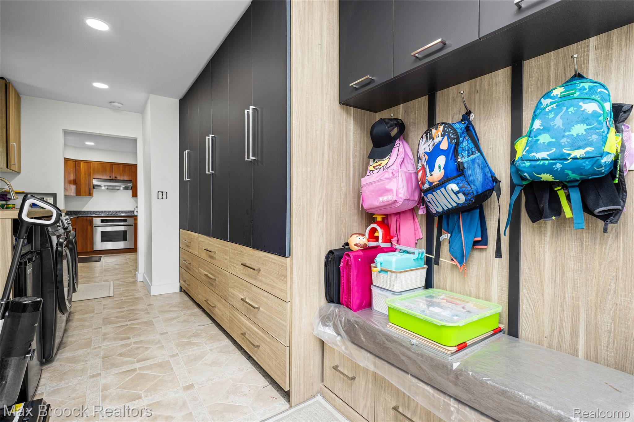 2810 Walbridge Drive Rochester, MI 48307 - Photo 25 of 58 Entryway featuring custom built-in cabinetry with light wood-finish and dark paneling, integrated bench seating, and overhead storage