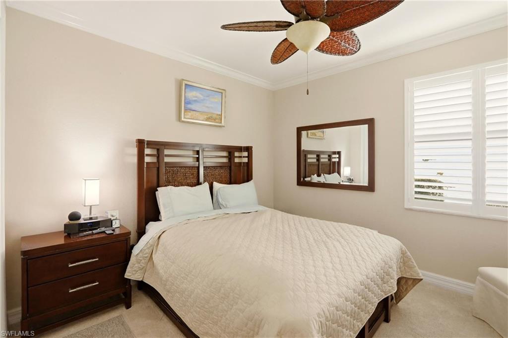 9238 Veneto Place, Unit 35 Naples, FL 34113 - Photo 27 of 49 a bedroom with a bed and a chandelier