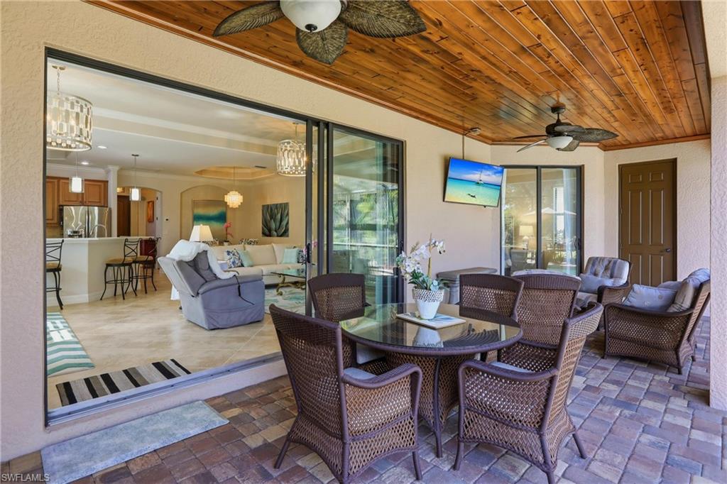 9238 Veneto Place, Unit 35 Naples, FL 34113 - Photo 33 of 49 a dining room with furniture a rug a potted plant and a chandelier
