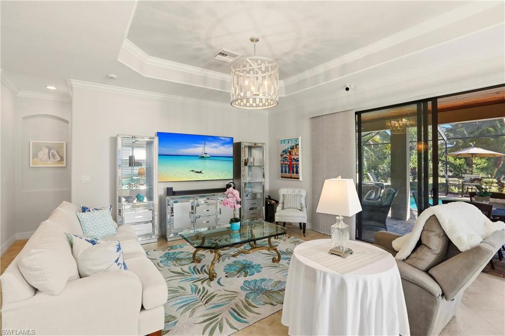 9238 Veneto Place, Unit 35 Naples, FL 34113 - Photo 4 of 49 a living room with furniture a chandelier and a large window