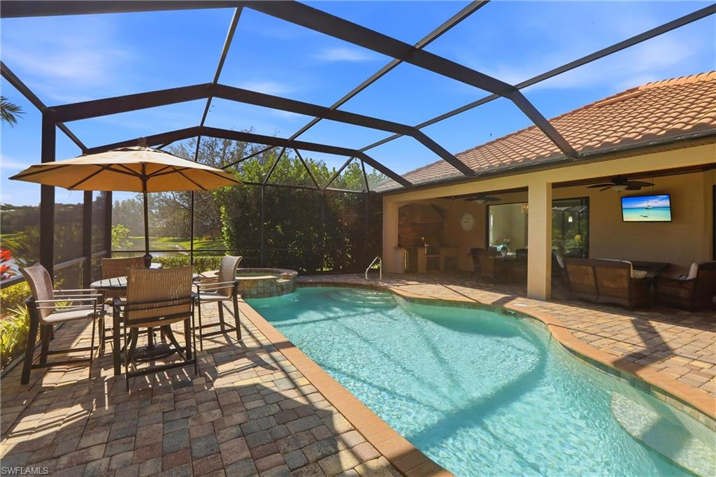 9238 Veneto Place, Unit 35 Naples, FL 34113 - Photo 41 of 49 a view of patio with chairs and table under an umbrella