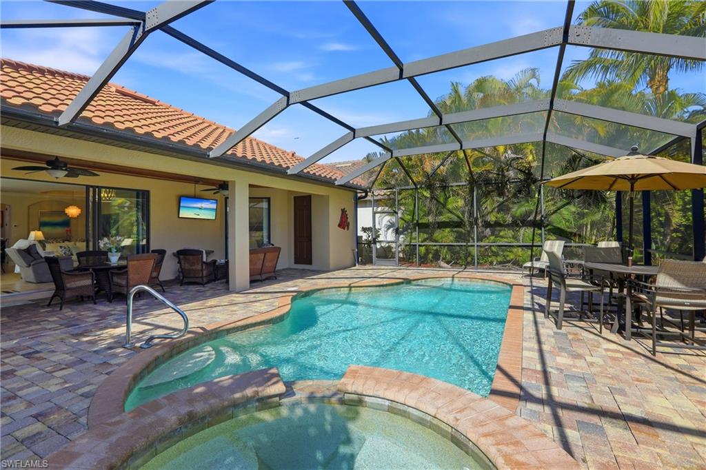 9238 Veneto Place, Unit 35 Naples, FL 34113 - Photo 42 of 49 a view of a patio with a table and chairs under an umbrella