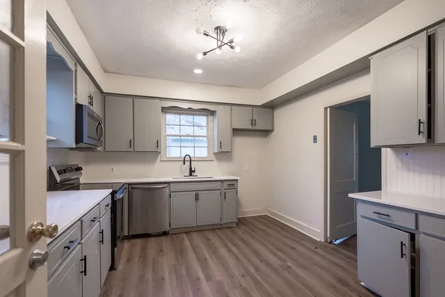 a kitchen with sink cabinets and wooden floor