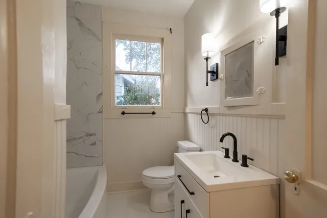 a bathroom with a sink a toilet and shower