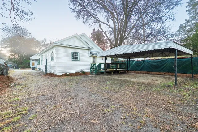 a view of a house with a yard and sitting area