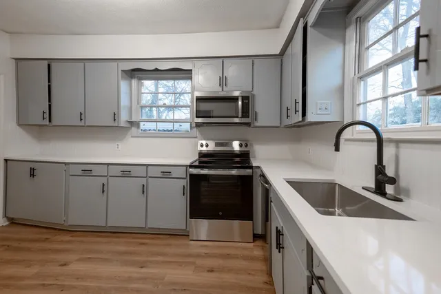 a kitchen with granite countertop a sink and a stove top oven