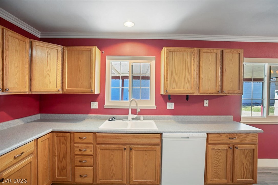 228 Redstone Street Las Vegas, NV 89145 - Photo 11 of 31 Kitchen with dishwasher, light countertops, ornamental molding, and wood finish cabinets