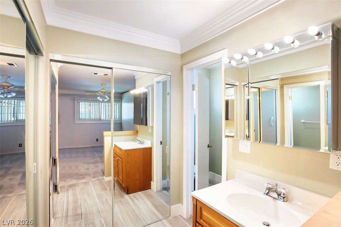 228 Redstone Street Las Vegas, NV 89145 - Photo 17 of 31 Bathroom featuring vanity, crown molding, wood finish floors, and a ceiling fan
