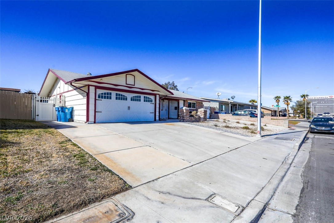 228 Redstone Street Las Vegas, NV 89145 - Photo 2 of 31 Ranch-style home featuring a gate, driveway, and a garage