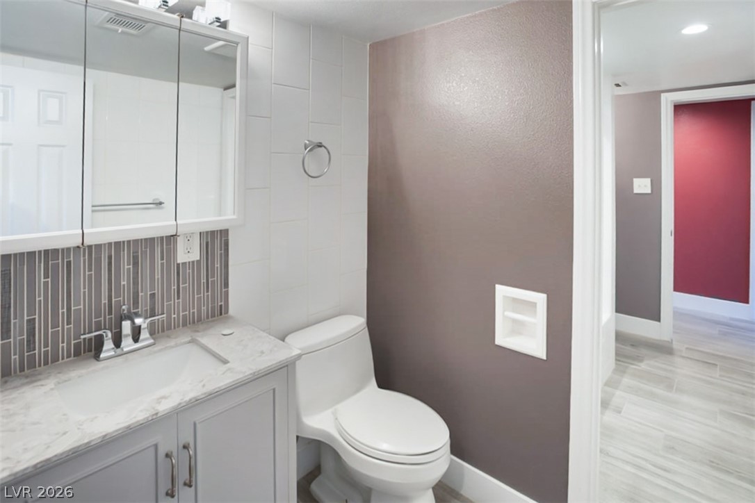 228 Redstone Street Las Vegas, NV 89145 - Photo 21 of 31 Bathroom with vanity, backsplash, and tile walls