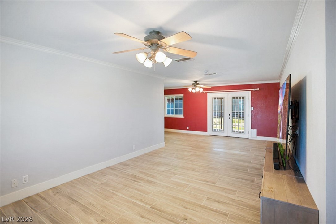 228 Redstone Street Las Vegas, NV 89145 - Photo 5 of 31 Unfurnished room with french doors, wood finish floors, ceiling fan, and crown molding