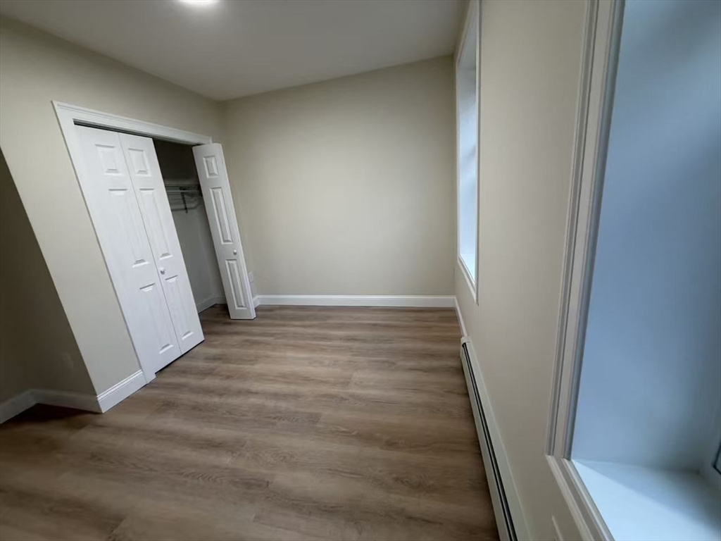 17 Hudson Street, Unit 2 Boston, MA 02111 - Photo 3 of 6 an empty room with wooden floor and closet