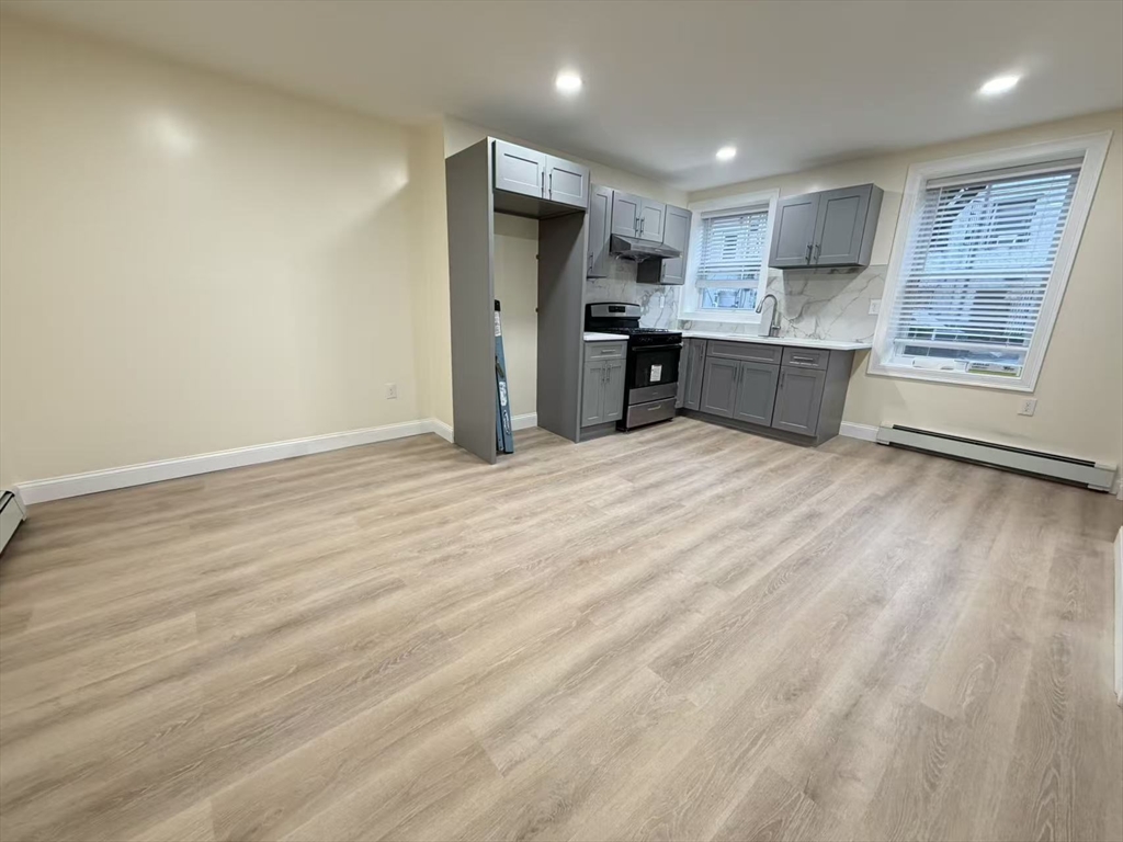 17 Hudson Street, Unit 2 Boston, MA 02111 - Photo 6 of 6 a large kitchen with stainless steel appliances granite countertop a stove a sink and a refrigerator