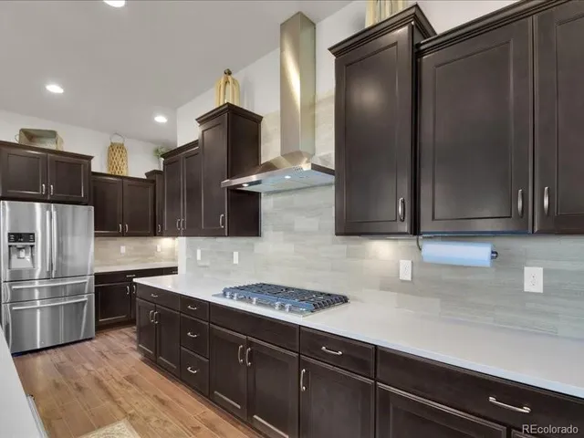 a kitchen with stainless steel appliances kitchen island granite countertop a sink a stove a dining table and chairs