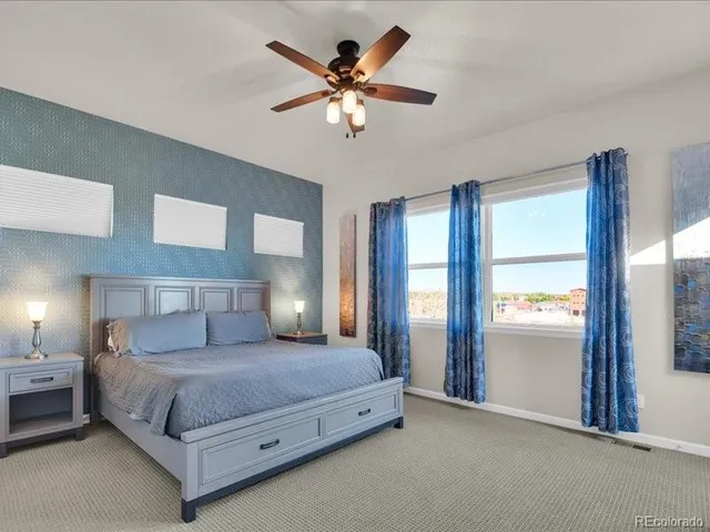 a spacious bedroom with a bed and a chandelier