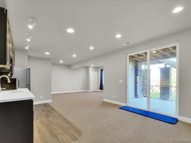 an empty room with kitchen and refrigerator