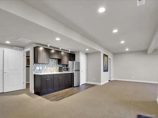 a large kitchen with stainless steel appliances granite countertop a refrigerator and a stove top oven