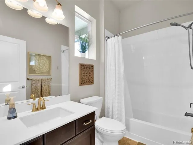 a bathroom with a sink a toilet a mirror and shower