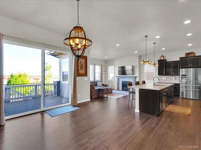 a view of a dining room and livingroom with furniture wooden floor a chandelier