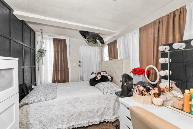 a bedroom with a bed and a mirror on the dresser