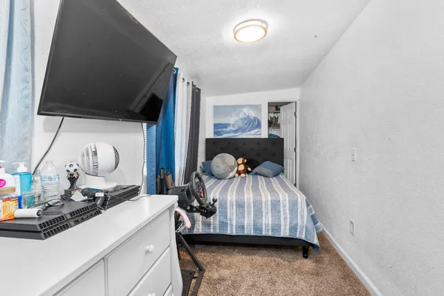 a living room with a bed furniture and a flat tv screen