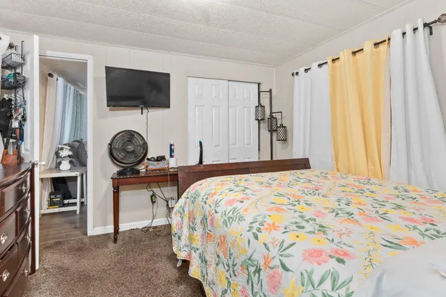 a bedroom with a bed a flat screen tv and a window