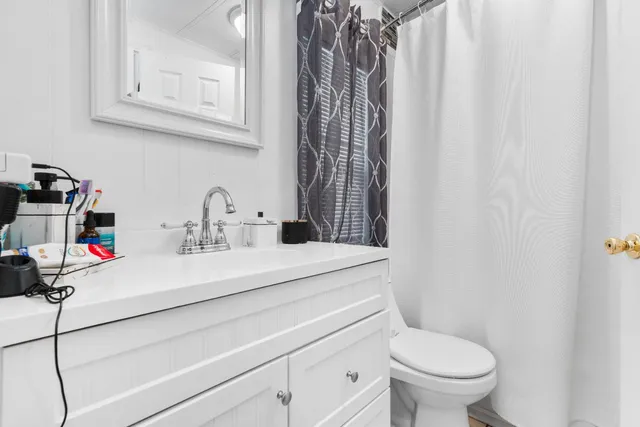 a bathroom with a sink a toilet and a mirror