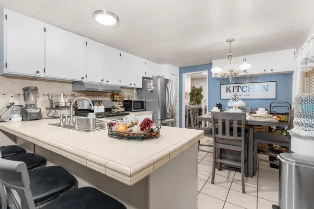 a kitchen with a sink a stove and chairs
