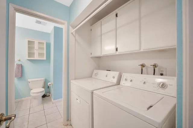 a view of washer and dryer with bathroom in the background