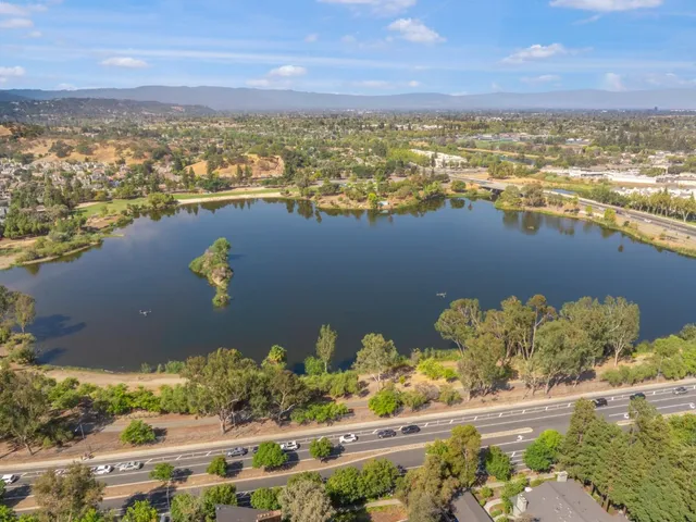 an aerial view of ocean and residential houses with outdoor space
