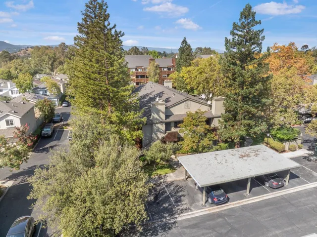 an aerial view of a house with yard and mountain view in back