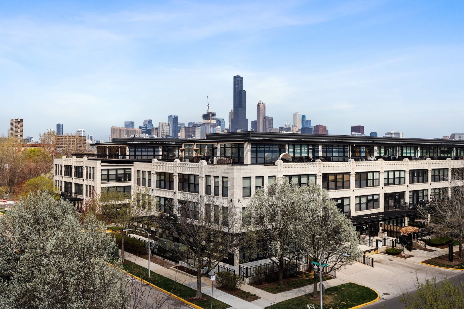 1111 West 15th Street, Unit 113 Chicago, IL 60608 - Photo 1 of 34 a view of a large building with a bench in front of it